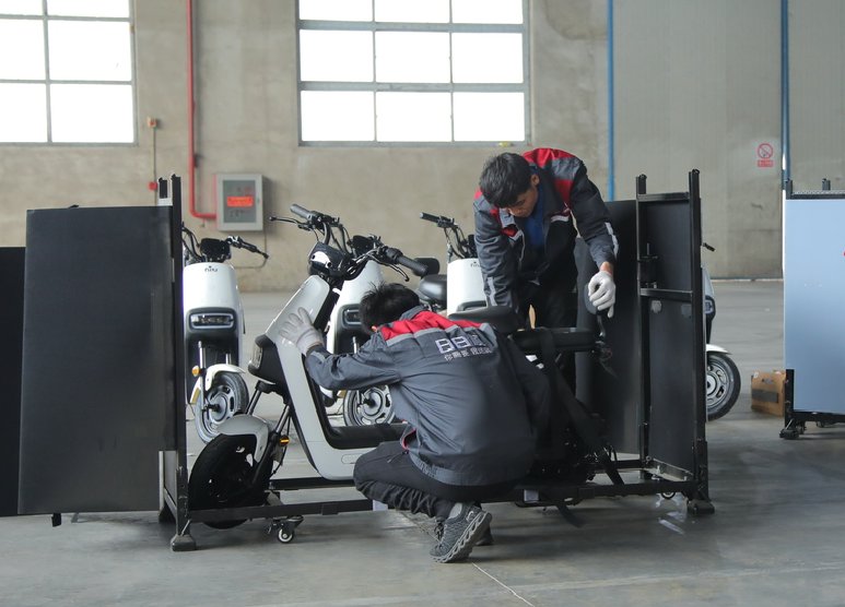 (场景服务师在前置装配中心对电动车进行组装)